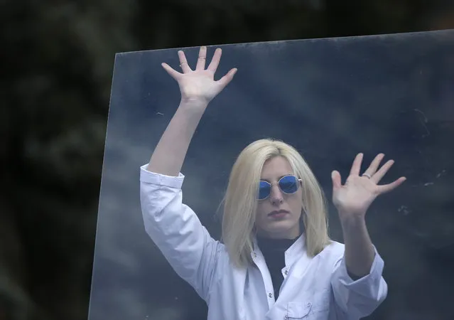 A woman performs behind “Glass Celling” during a rally to mark International Women's Day in Tbilisi, Georgia, March 8, 2017. (Photo by David Mdzinarishvili/Reuters)