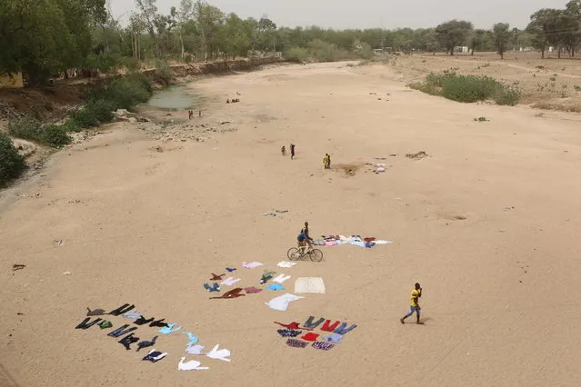 People wash clothes in a dry riverbed in Maroua, Cameroon, March 17, 2016. After watching its influence spread during a six-year campaign that has killed around 15,000 people according to the U.S. military, Nigeria has now united with its neighbours to stamp out Boko Haram. An 8,700-strong regional force of troops from Benin, Cameroon, Chad, Niger, and Nigeria is seeking to finish the job. Outside Nigeria, Cameroon has been hardest hit by Boko Haram, which now operates out of bases in the Mandara Mountains, Sambisa Forest and Lake Chad. (Photo by Joe Penney/Reuters)