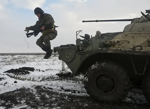 A Russian army service member jumps off an armoured personnel carrier BTR-82 during drills at the Kuzminsky range in the southern Rostov region, Russia on January 26, 2022. (Photo by Sergey Pivovarov/Reuters)