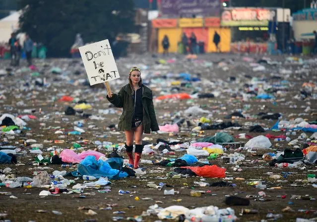 A reveller walks through rubbish left in front of the Pyramid Stage as they leave Worthy Farm in Somerset after the Glastonbury Festival in Britain, June 29, 2015. (Photo by Dylan Martinez/Reuters)