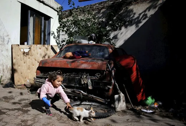 Mia Duarte plays with a cat at her house in Hurlingham, on the outskirts of Buenos Aires, Argentina, April 21, 2016. PIcture taken April 21, 2016. (Photo by Marcos Brindicci/Reuters)