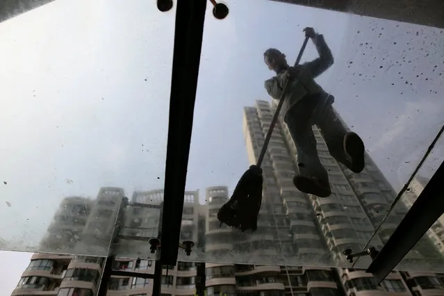 A man cleans the glass roof at the entrance of an apartment building constructed in 2004 after the demolition of old houses, at Guangfuli neighbourhood, in Shanghai, China, April 8, 2016. (Photo by Aly Song/Reuters)