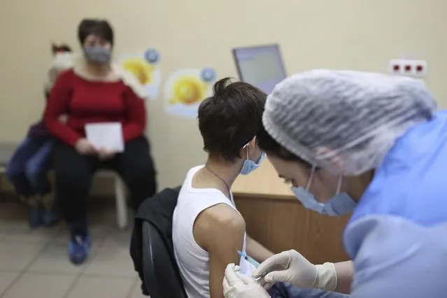 A teenager receives a dose of Russia's Sputnik M (Gam-COVID-Vac-M) COVID-19 vaccine in Krasnodar, Russia, Friday, February 4, 2022. The Russian president says his government is considering loosening some coronavirus restrictions, even as the country is facing a record-breaking surge of infections because of the highly contagious omicron variant. (Photo by Vitaliy Timkiv/AP Photo)