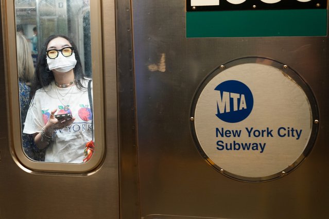 Commuters, one wearing a mask, ride the subway in New York, Friday, June 14, 2024. New York Gov. Kathy Hochul says she is considering a ban on face masks in the New York City subway system, following what she described as concerns over people shielding their identities while committing antisemitic acts. (Photo by Seth Wenig/AP Photo)