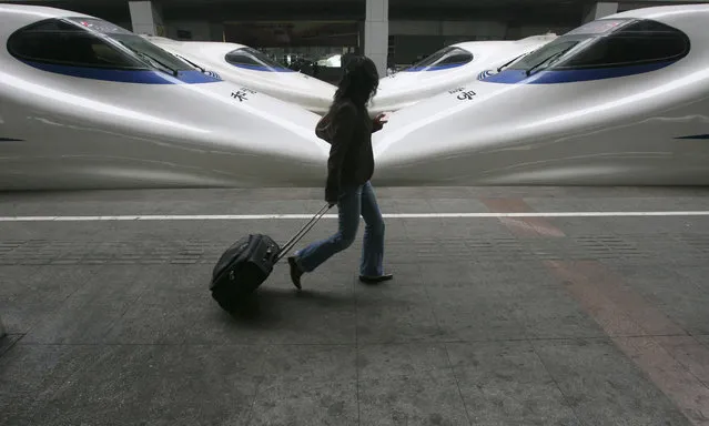 A passenger walks past high speed trains at a railway station in Nanjing, capital of east China's Jiangsu province Sunday, April 29, 2007. (Photo by Jeff Xu/Reuters)