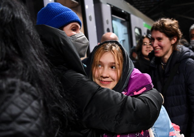 A woman welcomes a child who has arrived at Berlin's central station on a train from Poland, amid Russia's invasion of Ukraine, in Berlin, Germany, March 6, 2022. (Photo by Annegret Hilse/Reuters)