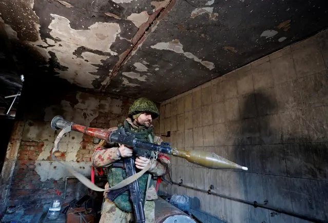 A service member of pro-Russian troops checks weapons inside a building, which according to the military, was previously a fighting position of Ukrainian armed forces, during Ukraine-Russia conflict in the town of Marinka, in the Donetsk Region, Ukraine on March 22, 2022. (Photo by Alexander Ermochenko/Reuters)
