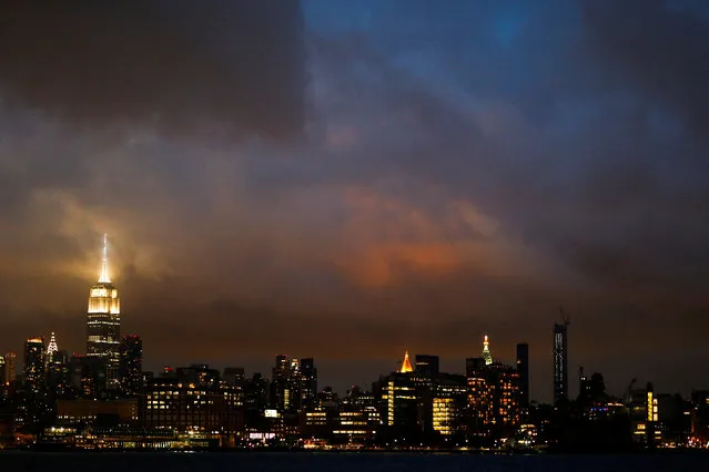 A low level cloud formation hovers over New York's Empire State Building and the skyline of midtown Manhattan as seen across the Hudson River in Hoboken, New Jersey, U.S., August 21, 2016. (Photo by Eduardo Munoz/Reuters)