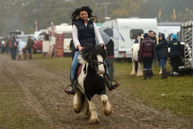 A woman rides a horse through the biannual Stow Horse Fair in the town of Stow-on-the-Wold, southern England on October 24, 2019. (Photo by Oli Scarff/AFP Photo)