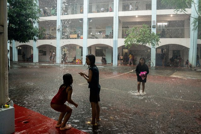 Children play in the rain at a school temporarily converted into an evacuation center following floods brought by Typhoon Gaemi, in Marikina City, Metro Manila, Philippines, on July 24, 2024. (Photo by Lisa Marie David/Reuters)