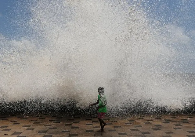 A young girl gets drenched in a large wave during high tide at a sea front in Mumbai, India, May 24, 2016. (Photo by Danish Siddiqui/Reuters)