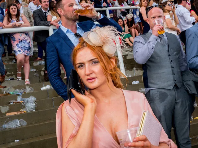 A woman on her cell phone during Ladies' Day at Epsom, England on June 2, 2017. Ladies' Day is traditionally held on the first Friday of June, a multitude of ladies and gents head to Epsom Downs Racecourse to experience a day full of high octane racing, music, glamour and fashion. (Photo by Peter Dench/Getty Images Reportage)