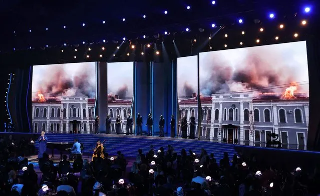 Ukrainian singer Mika Newton performs with John Legend in a tribute to Ukraine in front of images of a burning building during the 64th Annual Grammy Awards show in Las Vegas, Nevada, U.S. April 3, 2022. (Photo by Mario Anzuoni/Reuters)