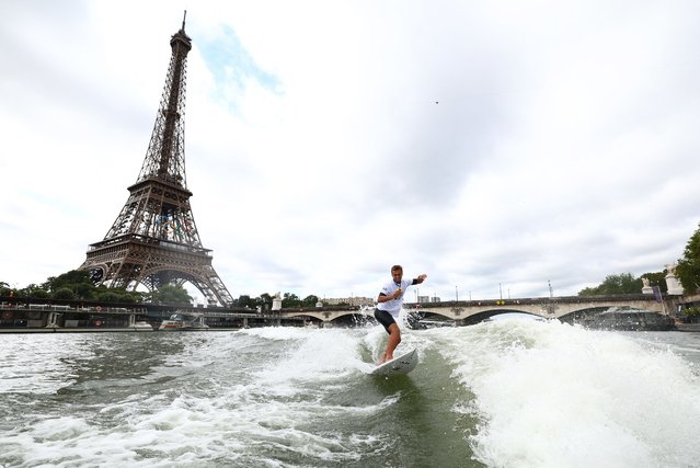 Gold medallist France's Kauli Vaast of Team France surfs in the Seine river with the Eiffel tower in the background during the Paris 2024 Olympic Games in Paris on August 9, 2024. (Photo by Franck Fife/AFP Photo)