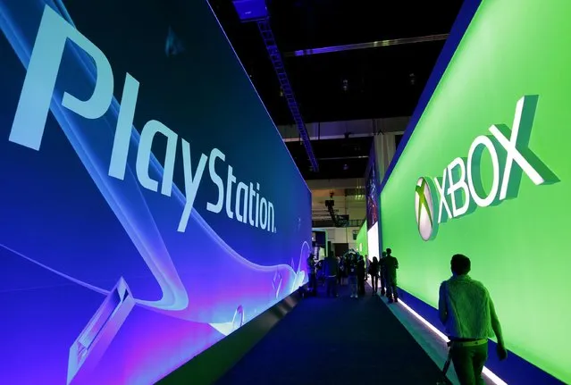 People walk past the Playstation and Xbox booths at the 2014 Electronic Entertainment Expo, known as E3, in Los Angeles, June 10, 2014.  REUTERS/Jonathan Alcorn