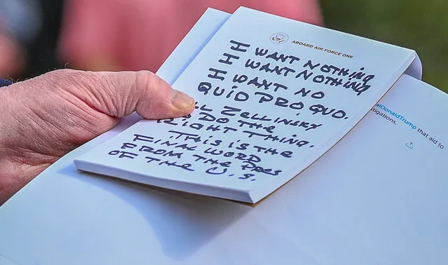 U.S. President Donald Trump holds what appears to be a prepared statement and handwritten notes after watching testimony by U.S. Ambassador to the European Union Gordon Sondland as he speaks to reporters prior to departing for travel to Austin, Texas from the South Lawn of the White House in Washington, U.S., November 20, 2019. (Photo by Erin Scott/Reuters)