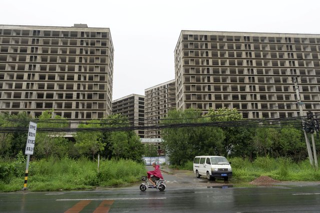 A rider passes by an abandoned construction project on the outskirts of Beijing, Thursday, July 25, 2024. (Photo by Ng Han Guan/AP Photo)