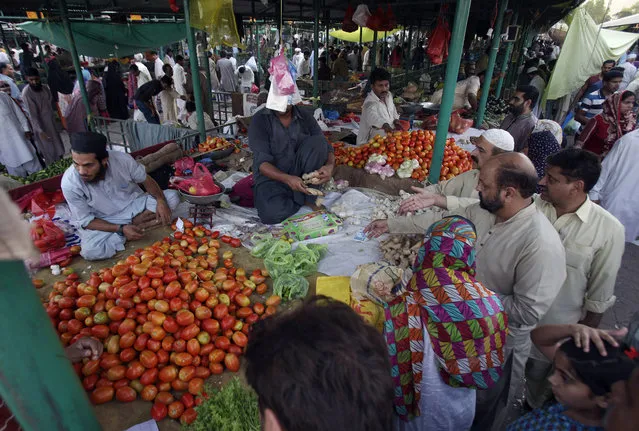 Shoppers buy foodstuff for the Muslim month of Ramadan, at a weekly market in Islamabad, Pakistan. Sunday, June 5, 2016. (Photo by Anjum Naveed/AP Photo)