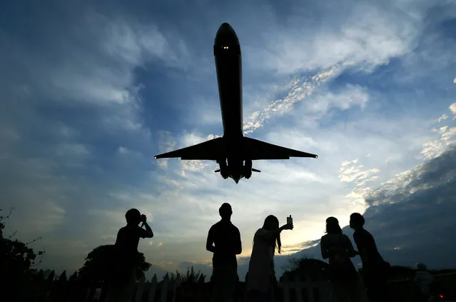People photograph an aeroplane approaching to land at Songshan Airport in Taipei, Taiwan, June 8, 2016. (Photo by Ritchie B. Tongo/EPA)