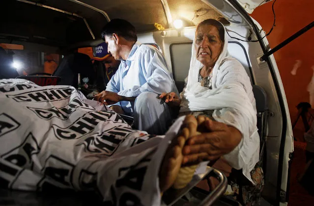 A mother of a policeman, who was killed along with three of his companions in a gun attack, touches the feet of her son while transporting his body in an ambulance outside a hospital morgue in Karachi, Pakistan June 23, 2017. (Photo by Akhtar Soomro/Reuters)