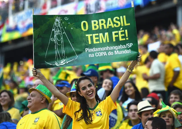 A Brazil fan holds up a sign during the 2014 FIFA World Cup Brazil Group A match between Brazil and Croatia at Arena de Sao Paulo on June 12, 2014 in Sao Paulo, Brazil. The banner says, “Brazil has faith!” (Photo by Christopher Lee/Getty Images)