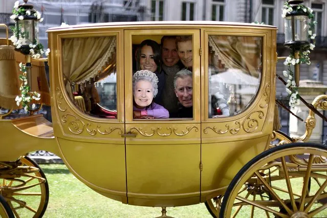 Cousins from the Goldhawk and Ganesan families pose whilst wear masks depicting members of the Royal Family as they play in a gold carriage in a park during Platinum Jubilee celebrations in London, Britain, June 1, 2022. (Photo by Tom Nicholson/Reuters)
