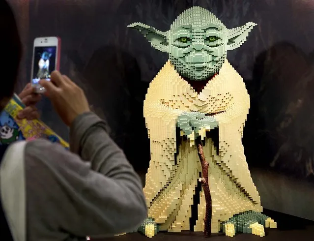 A visitor takes a picture of Star Wars character Yoda made from Lego blocks during the International Tokyo Toy Show in Japan on June 15, 2012