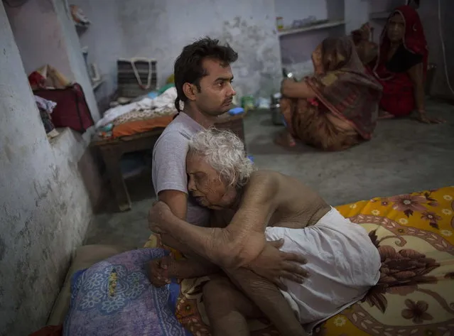 Bhogla Devi, 97, is comforted by her grandson Divyesh Tiwari as she cries in pain at Mukti Bhavan (Salvation House) in Varanasi, in the northern Indian state of Uttar Pradesh, June 17, 2014. (Photo by Danish Siddiqui/Reuters)