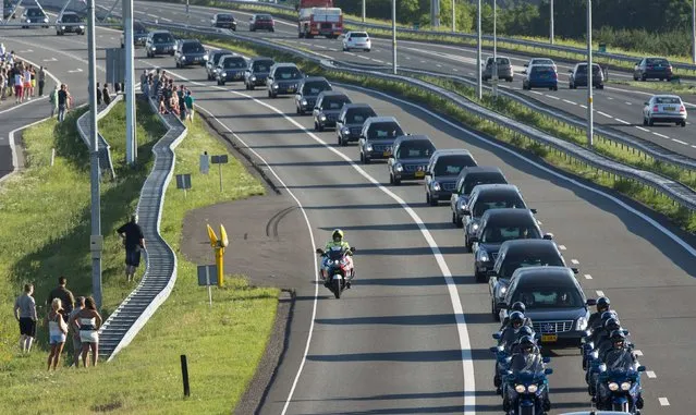 A row of hearses carrying victims of the Malaysia Airlines flight MH17 plane disaster are escorted on highway A27 near Nieuwegein by military police, on their way to be identified by forensic experts in Hilversum, July 23, 2014. The bodies of the first victims from the Malaysian airliner shot down over Ukraine last week arrived back in the Netherlands on Wednesday amid dignified grief tinged with anger. (Photo by Marco de Swart/Reuters)