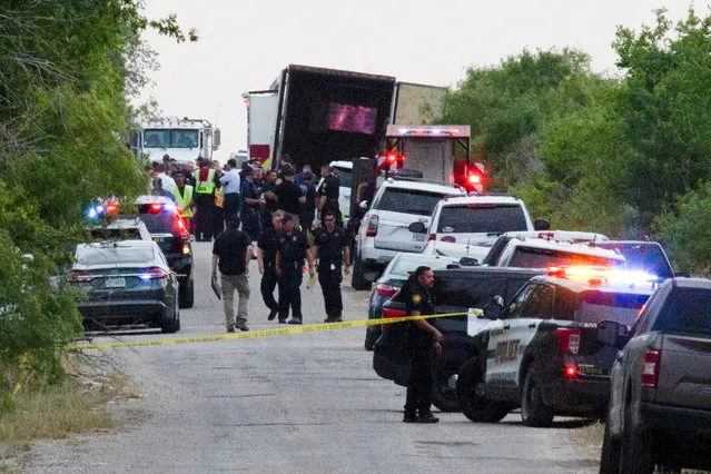 Law enforcement officers work at the scene where people were found dead inside a trailer truck in San Antonio, Texas, U.S. June 27, 2022. (Photo by Kaylee Greenlee Beal/Reuters)