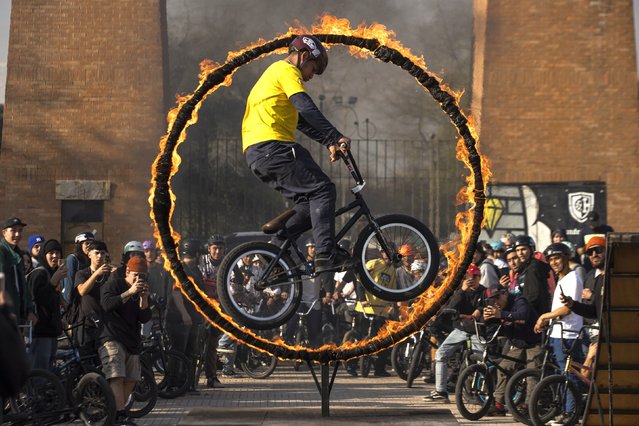 A cyclist performs a trick, during the BMX Day celebration in Santiago, Chile, 20 July 2022. (Photo by Alberto Valdes/EPA/EFE)