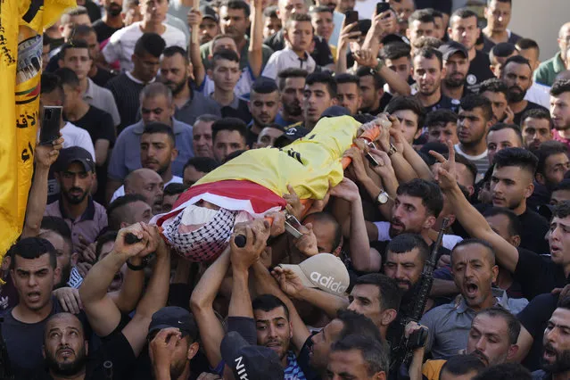 Palestinian mourners carry the body of Kamel Alawnah, who was shot by Israeli forces a day earlier, according to the Palestinian Ministry of Health, in the village of Jaba, near the West Bank city of Jenin, Sunday, July 3, 2022. The Israeli Defense Forces say a suspect hurled a Molotov cocktail at IDF soldiers in Jaba, who responded with live fire. (Photo by Majdi Mohammed/AP Photo)