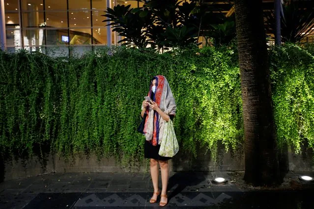 A woman wearing a protective mask stands as she waits for the bus at the sidewalk, after Indonesia confirmed its first cases of coronavirus, in Jakarta, Indonesia, March 4, 2020. (Photo by Willy Kurniawan/Reuters)