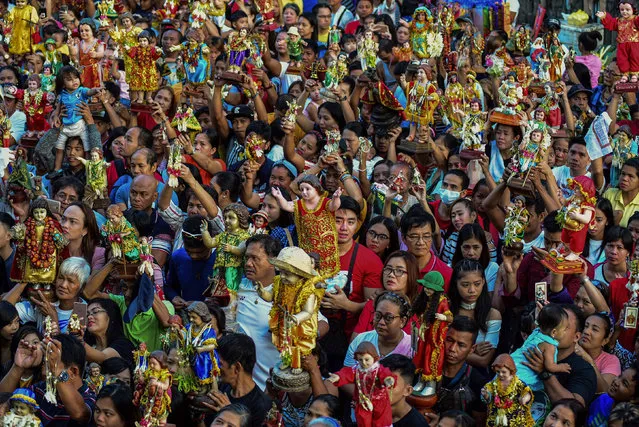 Devotees carry their religious icons of Santo Nino (holy child) to be blessed by priests during the annual festival in Manila on January 19, 2020. The Philippines is Asia's bastion of Catholicism and Santo Nino is one among dozens of religious festivals honouring various saints and religious icons, a legacy of three centuries of Spanish rule across the archipelago. (Photo by Maria Tan/AFP Photo)