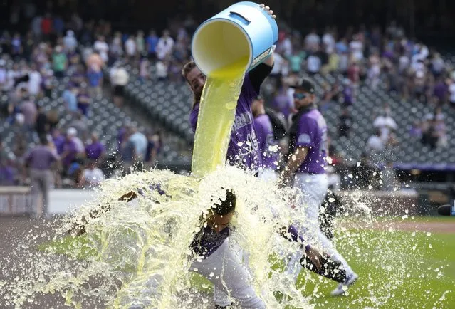 Colorado Rockies' Charlie Blackmon, back, douses Elias Diaz, who drove in the tying and winning runs off Chicago White Sox relief pitcher Kendall Graveman in the ninth inning of a baseball game Wednesday, July 27, 2022, in Denver. (Photo by David Zalubowski/AP Photo)