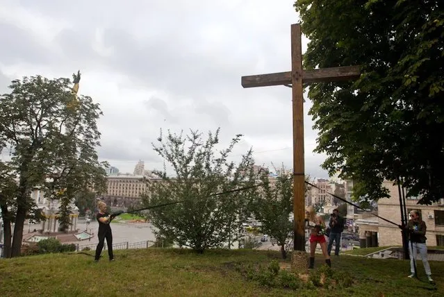 Ukraine FEMEN-activist Cuts Down Cross in Russian Female Punk Rock Band Protest