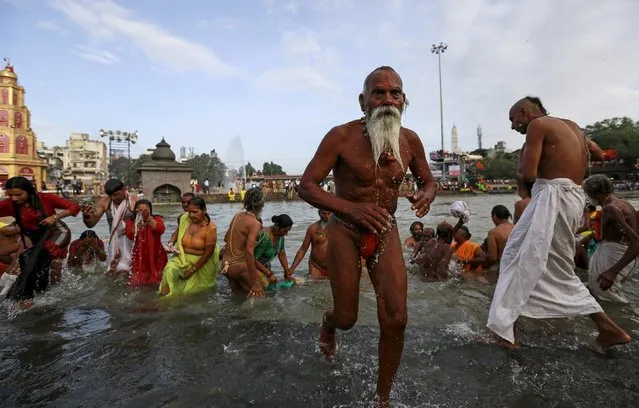 A Sadhu or a Hindu holy man leaves after taking a dip  in the Godavari river during the first Shahi Snan (grand bath) at Kumbh Mela, or Pitcher Festival in Nashik, India, August 29, 2015. Hundreds of thousands of Hindus took part in the religious gathering at the banks of the Godavari river in Nashik city at the festival, which is held every 12 years in different Indian cities. (Photo by Danish Siddiqui/Reuters)