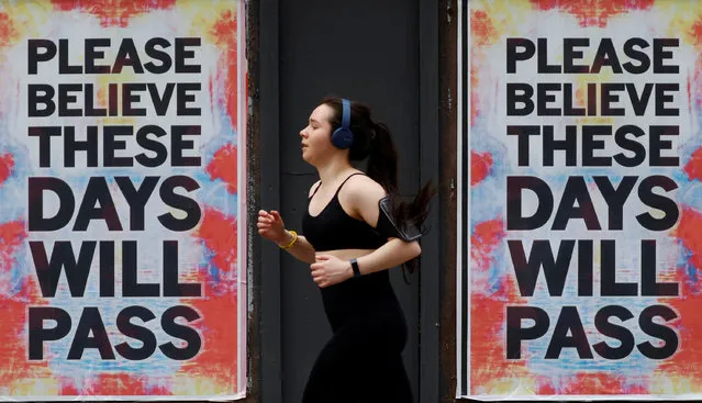 A person runs past posters with a message of hope, as the spread of the coronavirus disease (COVID-19) continues, in Manchester, Britain, April 12, 2020. (Photo by Phil Noble/Reuters)