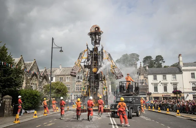 The giant 12-metre tall Man Engine is unveiled to the public in Tavistock on July 25, 2016 in Devon, England. Claimed to be the largest mechanical puppet made in Britain, standing at three times the height of a double decker bus, it has been created to mark the tenth anniversary of the date when the Cornwall and West Devon Mining Landscape was added to the Unesco list of World Heritage Sites. Starting today it will journey to the the mining world heritage sites accompanied by more than a dozen “miners” and traditional 'bal-maidens' who have the job of animating the steam-powered giant. (Photo by Matt Cardy/Getty Images)