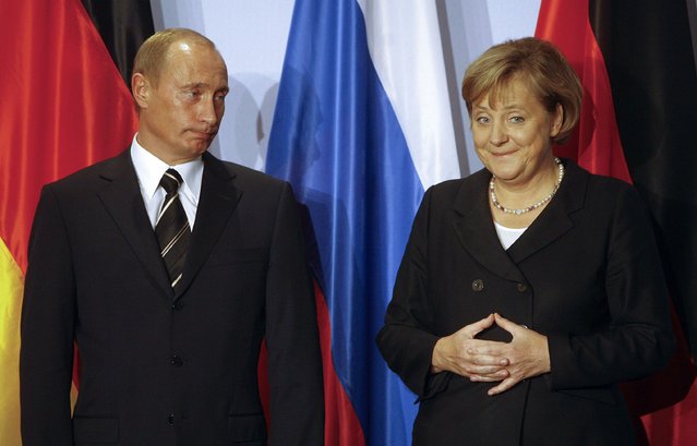 German Chancellor Angela Merkel, right, and Russian President Vladimir Putin hold a news conference after bilateral talks in Dresden, on October 10, 2006. Merkel has been credited with raising Germany’s profile and influence, helping hold a fractious European Union together, managing a string of crises and being a role model for women in a near-record tenure. Her designated successor, Olaf Scholz, is expected to take office Wednesday, Dec. 8, 2021. (Photo by Markus Schreiber/AP Photo/File)