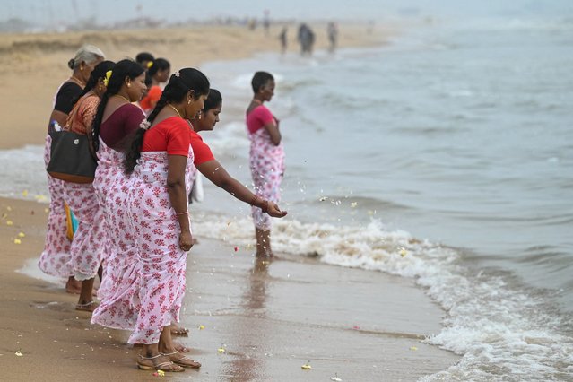 Women perform rituals during a ceremony held on the 20th anniversary for the victims of the 2004 Indian Ocean tsunami, at Pattinapakkam beach in Chennai on December 26, 2024. Tearful mourners prayed on December 26, 2024, as ceremonies began across Asia to remember the 220,000 people who died two decades ago when a tsunami hit coastlines around the Indian Ocean, in one of the world's worst natural disasters. (Photo by R.Satish Babu/AFP Photo)