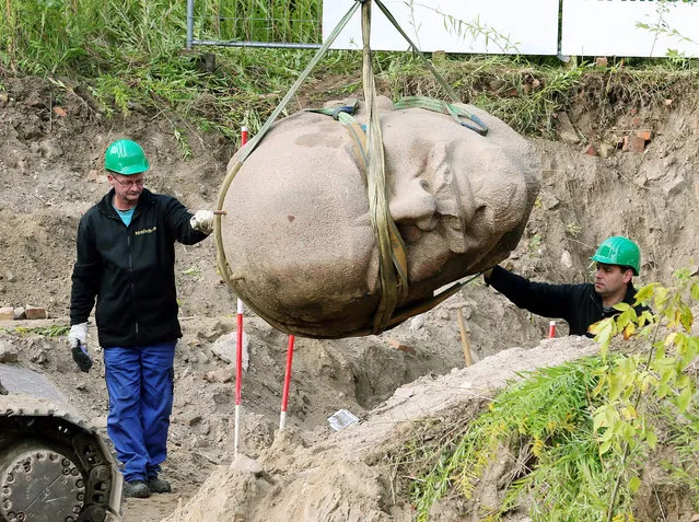 Workers secure a giant Lenin head, which is carried by a crane, in a forest in Berlin, Germany, 10 September 2015. The head of the Lenin monument, which was dismantled in 1991, will be part of the exhibition “Enthuellt. Berlin und seine Denkmaeler” (“Revealed. Berlin and its monuments”). (Photo by Wolfgang Kumm/EPA)