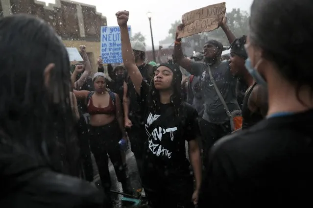 Rain falls as C'Monie Scott raises her fist while people chant around her at a memorial site for George Floyd that has been created at the place where he was taken into police custody and later pronounced dead, in Minneapolis, Minnesota, June 2, 2020. (Photo by Leah Millis/Reuters)