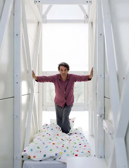 Etgar Keret, a writer of short stories, stands on Ikea sheets in the bedroom of the Keret House. (Photo by Andrea Meichsner/The New York Times)