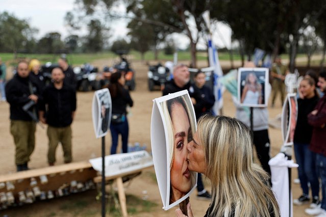A woman kisses a picture of Mercedes Oria Amar who was killed at the site of the Nova festival, where people were killed and kidnapped during the October 7 attack by Hamas gunmen from Gaza, on the day of a press conference held by family members and relatives of Nova festival attendees, in Reim, in southern Israel on January 5, 2024. (Photo by Tyrone Siu/Reuters)