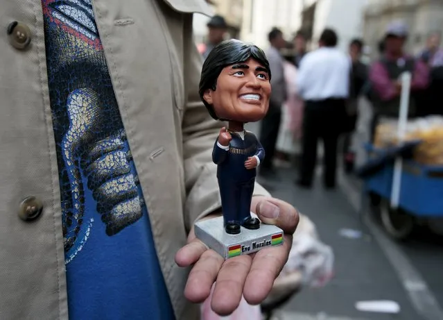 A man holds a figurine of Bolivia's President Evo Morales before a ceremony where members of the CONALCAM, the National Council for Change, presented deputies a document put together by supporters of Bolivia's President Evo Morales to ask for a change in the Bolivian constitution to allow Morales to access re-election as president of Bolivia for a fourth time, in La Paz, September 17, 2015. (Photo by David Mercado/Reuters)