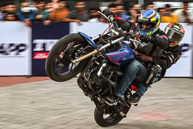 Bikers perform stunts as they demonstrate their skills during an event at a mall in Chennai on October 15, 2022. (Photo by Arun Sankar/AFP Phoot)