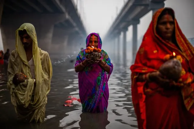 Hindu devotees perform rituals to the Sun god in the river Yamuna during Chhath Parva Festival in Noida the outskirts of New Delhi, India on October 31, 2022. Chhath puja, an ancient Hindu festival, rituals are performed to thank the Sun god for sustaining life on earth. (Photo by Amarjeet Kumar Singh/Anadolu Agency via Getty Images)