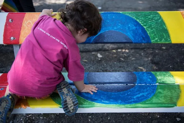 A child sits on a bench painted in rainbow colors created by the artist Rosalba Castelli on June 20, 2020 in Turin, Italy. Though the Turin Pride 2020 is digital due to the Covid-19 measures, some people wanted to celebrate it on the streets. (Photo by Stefano Guidi/Getty Images)
