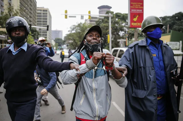 Kenyan policemen detain a protester at a demonstration in downtown Nairobi, Kenya Tuesday July 7, 2020. Kenyan police have fired tear gas and detained scores of protesters who were demanding an end to police brutality. (Photo by Brian Inganga/AP Photo)